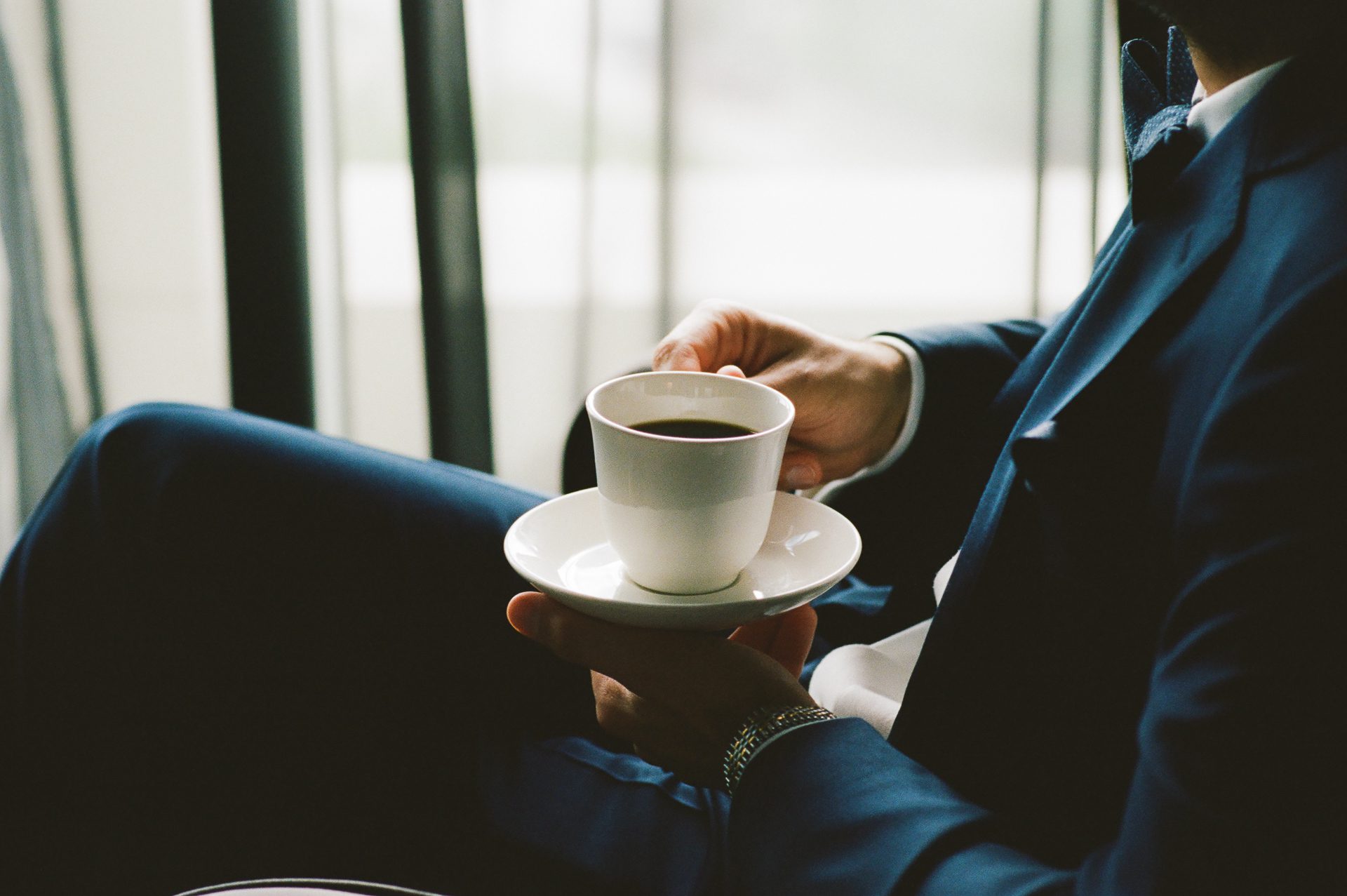 Candid moment of Groom on wedding morning with a cup of coffee